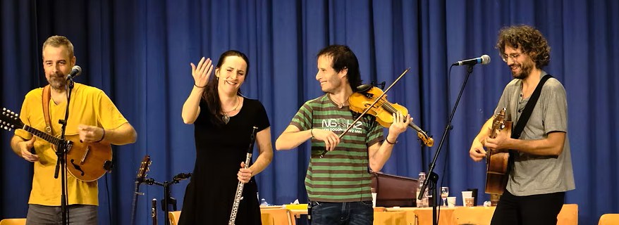 Grand Balthazar auf der B&uuml;hne: Mandoline, Querfl&ouml;te, Geige und Gitarre vor blauem Vorhang